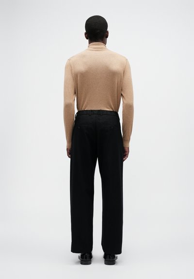 Suéter de gola alta amarelo, calças largas pretas, cores sólidas, textura suave, vista traseira, design simples, detalhes mínimos.