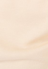 Lichtbeige ribstof met een zachte textuur, voorzien van verticale strepen in een consistent patroon.