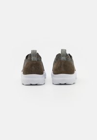 Sneaker in tessuto grigio con dettagli in camoscio, suola bianca, parte superiore elastica e linguette sul retro per una facile calzata.