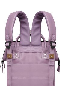 Sac à dos lilas avec des bretelles rembourrées, un tissu texturé, une poche zippée et des accents en cuir avec des détails à pression. Design ergonomique.