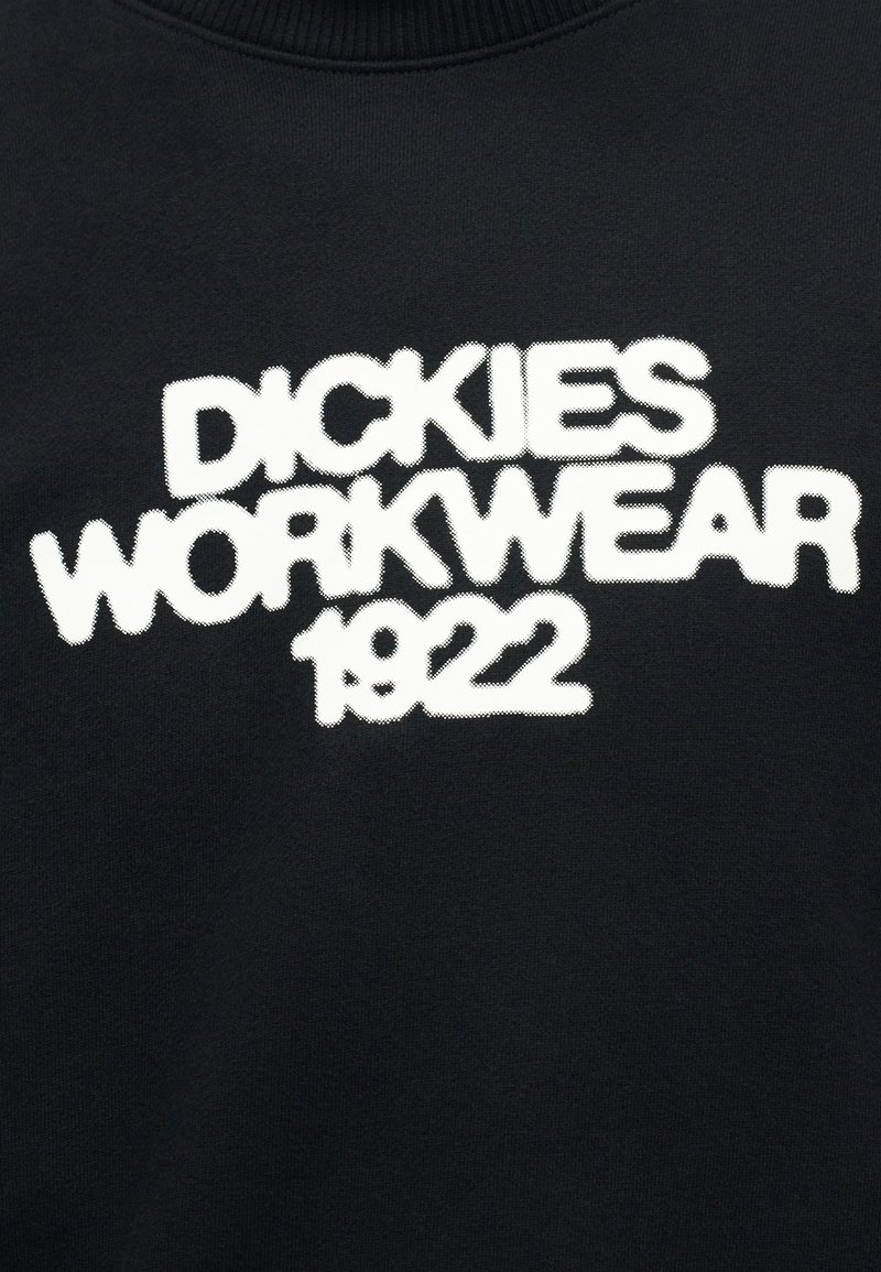 Tessuto nero con testo bianco audace che recita "DICKIES WORKWEAR 1922" in carattere stilizzato.