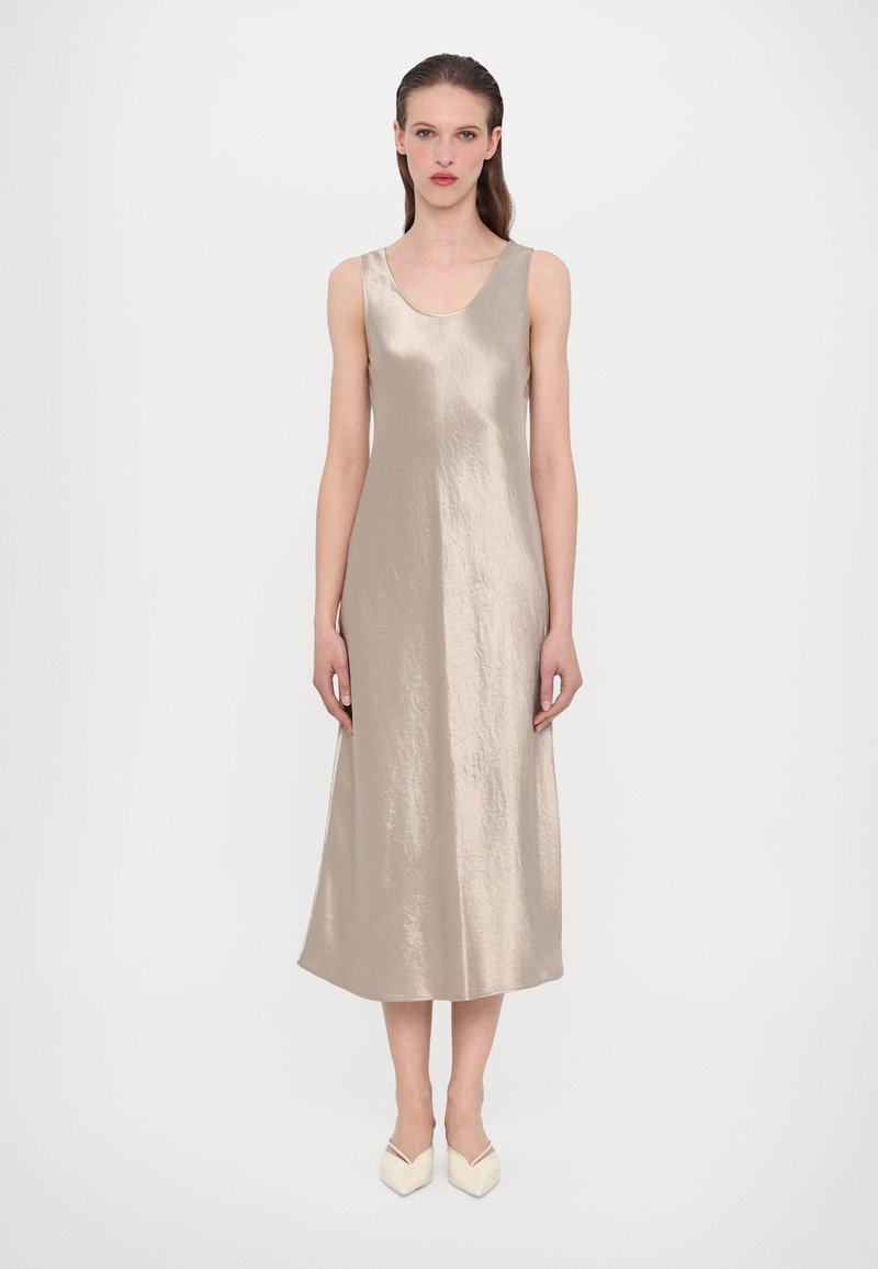 Satin beige ermeløs kjole med rundhals, som faller til midt på leggen, med en glatt tekstur og subtil glans. Minimalistisk design.