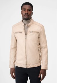 Beige læderjakke med høj krave, lynlåslommer på brystet og sidelommer. Glat tekstur, figursyet design og stitch-detaljer.