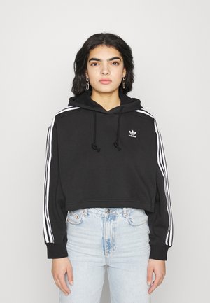 Sudadera corta negra con cordón, que presenta acentos de tres rayas blancas a lo largo de las mangas y un pequeño logo en el pecho.