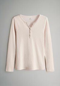 Pikad varrukad, helesinine tipp, mis on valmistatud soonikust kangast, V-kaelusega ja viie nuppudega plakeerimisega, millel on ees nupumoodulid.