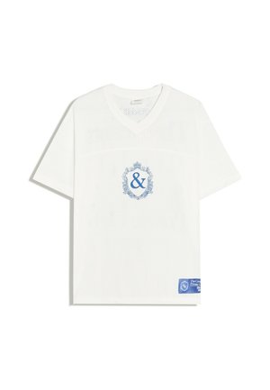 Biały, siatkowy T-shirt z krótkim rękawem i dekoltem w serek, z niebieskim ozdobnym symbolem ampersanda na piersi oraz niebieską prostokątną metką w pobliżu dolnego brzegu.