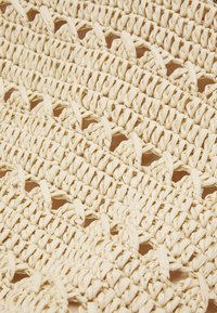 Geweven mat van natuurlijke vezels met een gestructureerd, beige oppervlak, een open, verstrengeld patroon en strak gerangschikte draden.