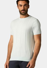 Hellblauer Kurzarm-Pullover mit gerippter Textur und vertikalem Streifenmuster. Hergestellt aus weichem Stoff mit Rundhalsausschnitt und taillierter Passform.