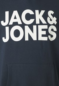 Marineblauwe hoodie met grote witte tekst "JACK & JONES," met een stevige textuur en een kangoeroezak aan de voorkant.