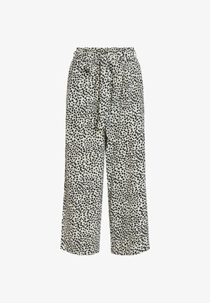 Hlače širokih nogavica s visokim strukom, ukrašene crnim nepravilnim točkama na bijelom platnu, s remenom od istog materijala vezanim u mašnu u struku.