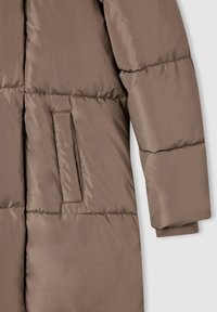 Giacca imbottita marrone con tessuto texturizzato e lucido; include una tasca laterale e polsini a costine per una maggiore comodità.
