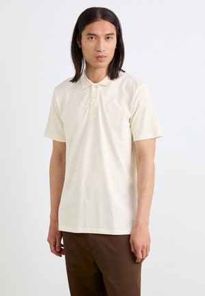 Kremfarget kortermet polo skjorte laget av mykt stoff, med klassisk krage og to knapper, og med en diskret brodert logo på brystet.
