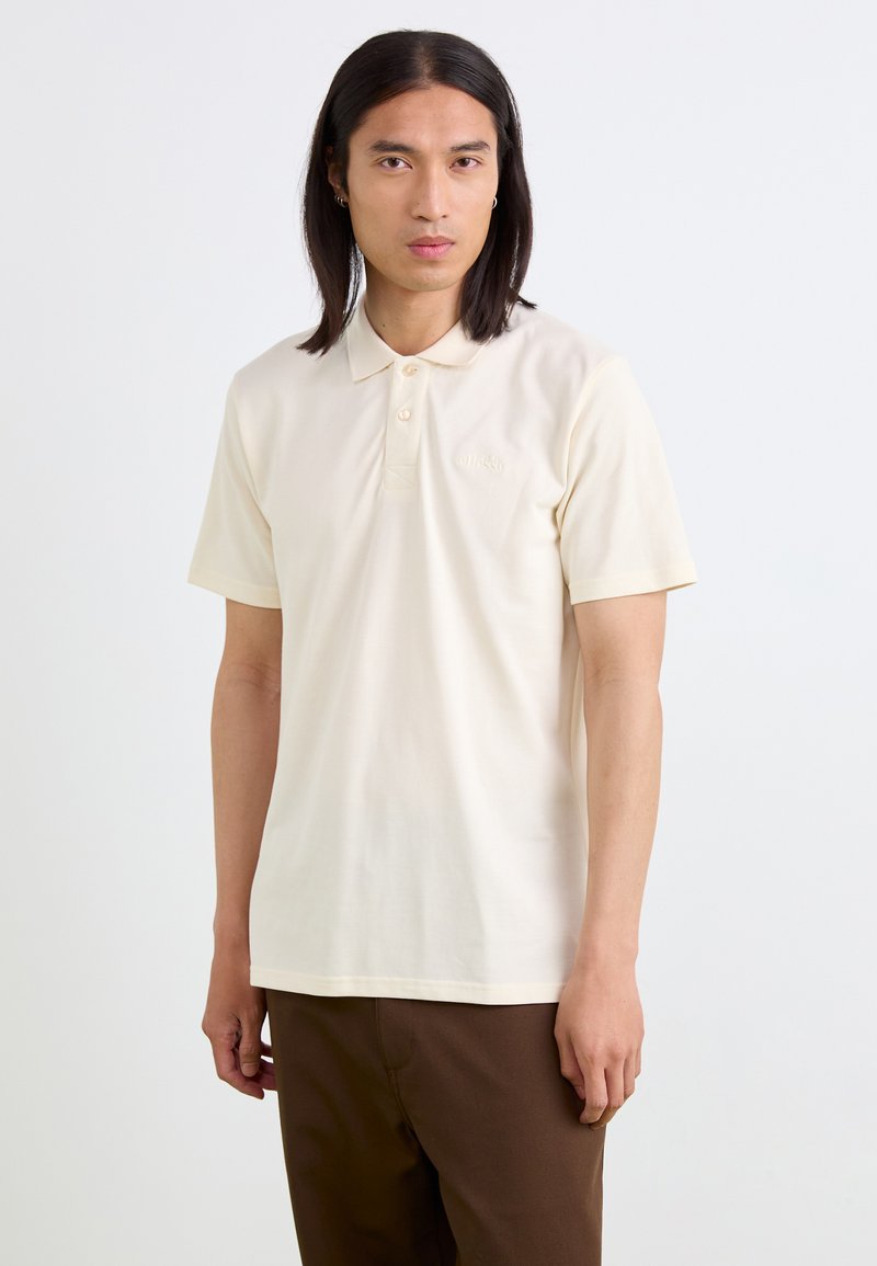 Polo a maniche corte di colore crema realizzato in tessuto morbido, con colletto classico e due bottoni, decorato con un discreto logo ricamato sul petto.