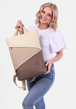 Tan- und brauner Rucksack mit einem dreieckigen Design, aus strapazierfähigem Stoff, verstellbaren Trägern und einer Reißverschlusstasche.