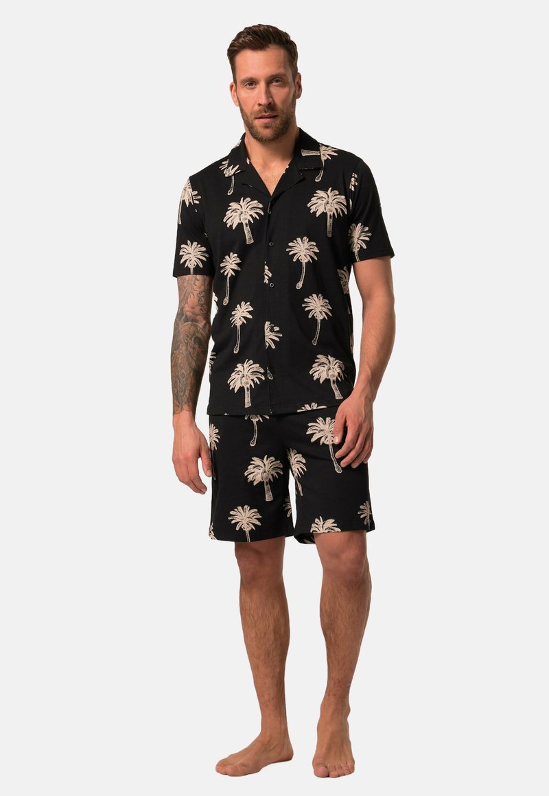 Conjunto de camisa de manga corta negra y pantalones cortos con un estampado de palmeras en beige. El material parece ligero; el patrón se repite en ambas piezas.