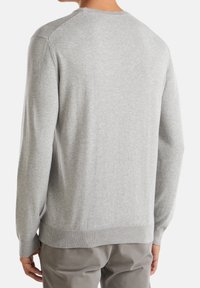 Ljusgrå tröja med rund hals, stickad textur och ribbade muddar och nederkant. Har en sömlös design med raglanärmar.