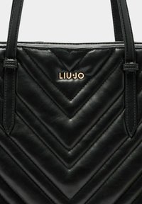 Zwarte gewatteerde leren handtas met chevronpatroon, voorzien van een gouden "LIU.JO" logo en dubbele handvatten om te dragen.