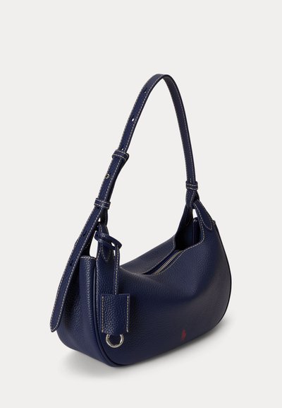 Borsa a tracolla in pelle traforata blu navy con tracolla regolabile, chiusura con zip e piccolo logo rosso vicino alla base.