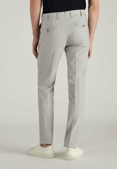 Lichtgrijze broek van een gestructureerde stof. Slim fit ontwerp met twee achterzakken met knopen. Gecombineerd met witte sneakers.
