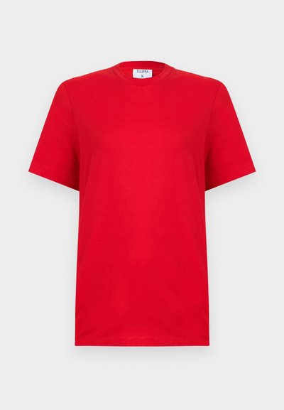 Απλό κόκκινο κοντομάνικο T-shirt με στρογγυλή λαιμόκοψη και ετικέτα Filippa K στο εσωτερικό του γιακά, παρουσιάζεται σε ανοιχτό γκρι φόντο.