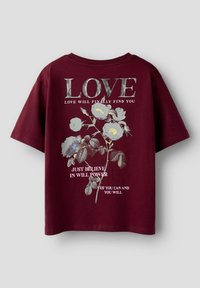 Camiseta de algodón color marrón con cuello redondo, que presenta un diseño floral y texto en colores contrastantes: "AMOR" y frases motivacionales abajo.