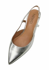 Srebrny metaliczny but na słupku z wydłużonym noskiem i gładką strukturą; posiada cienki pasek na kostkę i jasnobrązowe wnętrze.