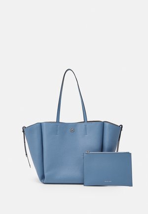 Sac cabas en cuir bleu avec deux poignées et une pochette zippée assortie placée devant sur un fond blanc.