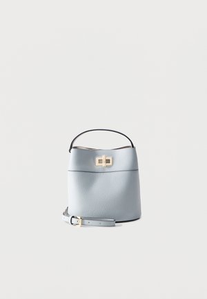 Light blue textured leather bucket bag with top handle, gold turn-lock clasp, and detachable strap placed beside it.