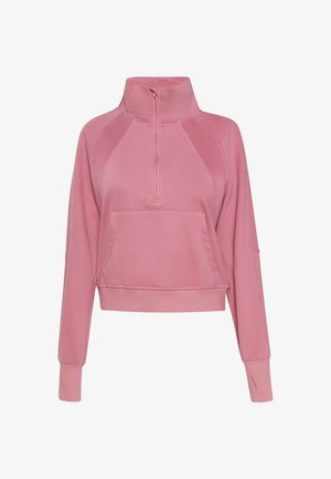 Różowa, skrócona bluza z wysokim kołnierzem, zamek błyskawiczny z przodu i długimi rękawami. Posiada kieszeń z przodu i ściągacze przy rękawach. Miękka w dotyku.