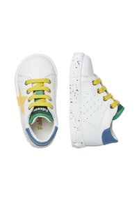 Scarpe in pelle bianca con lacci gialli e un accento verde. Presentano un tallone blu, un design a stella e delle macchie multicolori sulla suola.