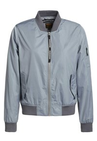 Blouson bomber gris clair avec fermeture éclair frontale, deux poches à boutons-pression, col, poignets et ceinture côtelés, et une petite poche zippée sur la manche gauche.