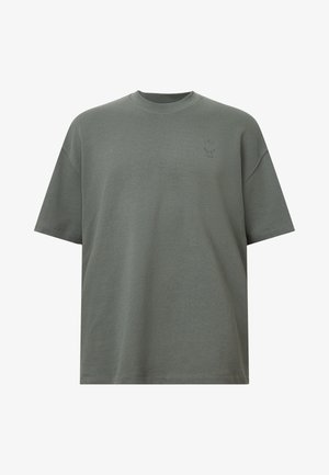 Olijf groene oversized katoenen t-shirt met een ronde hals, korte mouwen en een klein logo detail op de borst. Soepele textuur, ontspannen pasvorm.