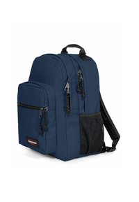 Mochila azul marino con compartimentos acolchados, múltiples bolsillos con cremallera y un bolsillo lateral de malla. Hecha de un tejido duradero con cremalleras negras.