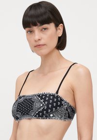 Juodas bandeau tipo bikini viršus, dekoruotas paisley ir gėlių raštais, su reguliuojamomis juodomis petnešomis ir kontrastinga dekoratyvine siuvimo linija.
