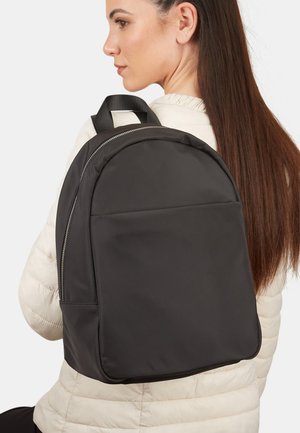 Mochila negra hecha de nylon suave, de forma redondeada, con cierre de cremallera y asas cortas para llevar. Diseño simple, sin patrones visibles.