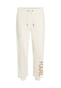 Crème kleurige sweatpants met een elastische tailleband, een trekkoord en "KARL" in het goud gedrukt op het linkerpijp. Zacht materiaal, taps toelopende boorden.