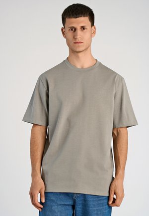 Maglietta grigia a maniche corte con scollo rotondo, realizzata in morbido cotone, caratterizzata da una vestibilità rilassata e un design minimalista.