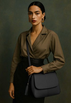 Femme aux cheveux bruns portant une chemise marron et une jupe noire, tenant un sac en cuir noir à bandoulière avec des boucles d'oreilles en or contre un fond sombre.