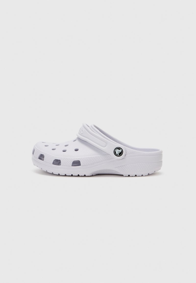 White clog with open ventilation holes, raised heel, molded structure, and a black logo accent on the side. Adjustable back strap for fit.