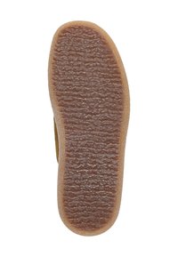 Braune Gummisohle mit einem strukturierten Grip-Muster und abgerundeten Kanten. Die Oberfläche zeigt erhabene Linien für die Traktion.