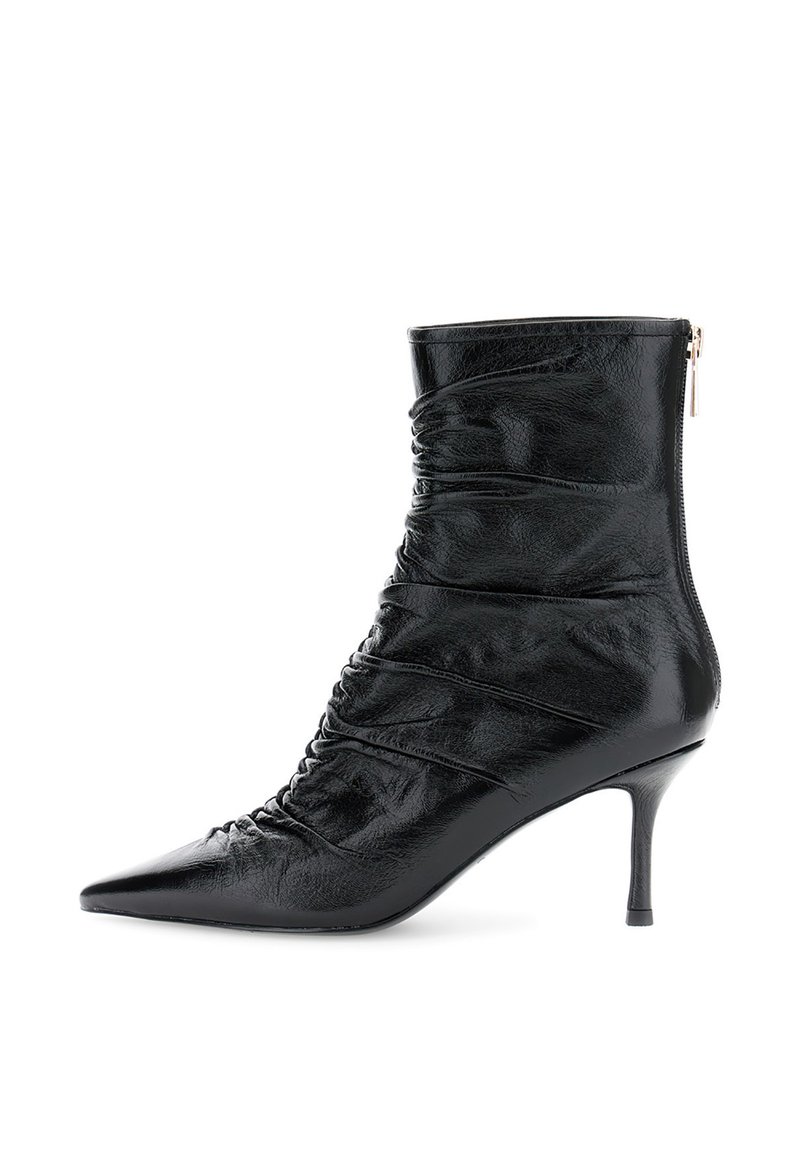 Bota de tobillo negra con puntera afilada, de cuero arrugado y un tacón slim de altura media, que cuenta con un cierre de cremallera en la parte trasera.