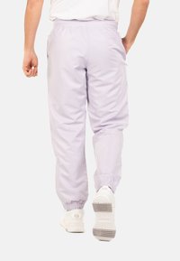 Lichtpaarse, lichte joggers met elastische boorden en tailleband. Voorzien van zijzakken en een gladde, licht glanzende textuur.