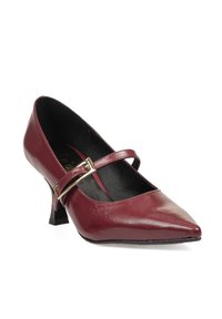 Zapato de charol burdeos con punta afilada, tacón de altura media y una correa decorativa con una hebilla metálica. Textura suave con un acabado brillante.