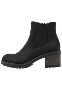 Botas de tobillo negras con una textura suave similar al ante, paneles laterales elásticos, puntera redondeada y un tacón grueso y estampado. Suela con diseño único.