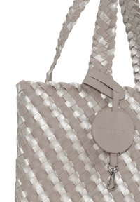Flätad tote-väska i ljusgrått med metalliska detaljer. Har en rund lädertagg och stadiga vävda handtag. Strukturerad yta.