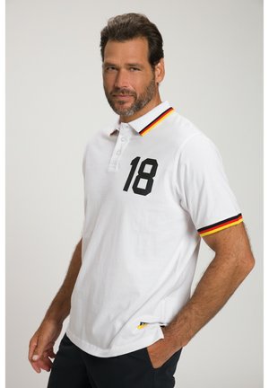 Hvid polo-shirt med sort nummer "18" på brystet, sort og rødstribet krave. Lavet af bomuldsmateriale med en klassisk pasform og korte ærmer.
