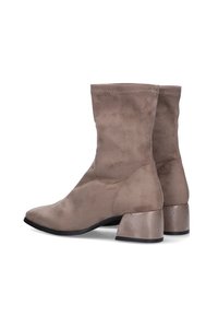 Botas de tobillo color topo hechas de suave ante, con un tacón grueso, punta afilada y parte superior sin costuras con sutiles detalles de costura.