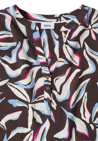 Blouse marron avec de grands motifs abstraits de feuilles blanches, bleu clair et roses, col rond avec trois boutons et étiquette de marque "Cecil".