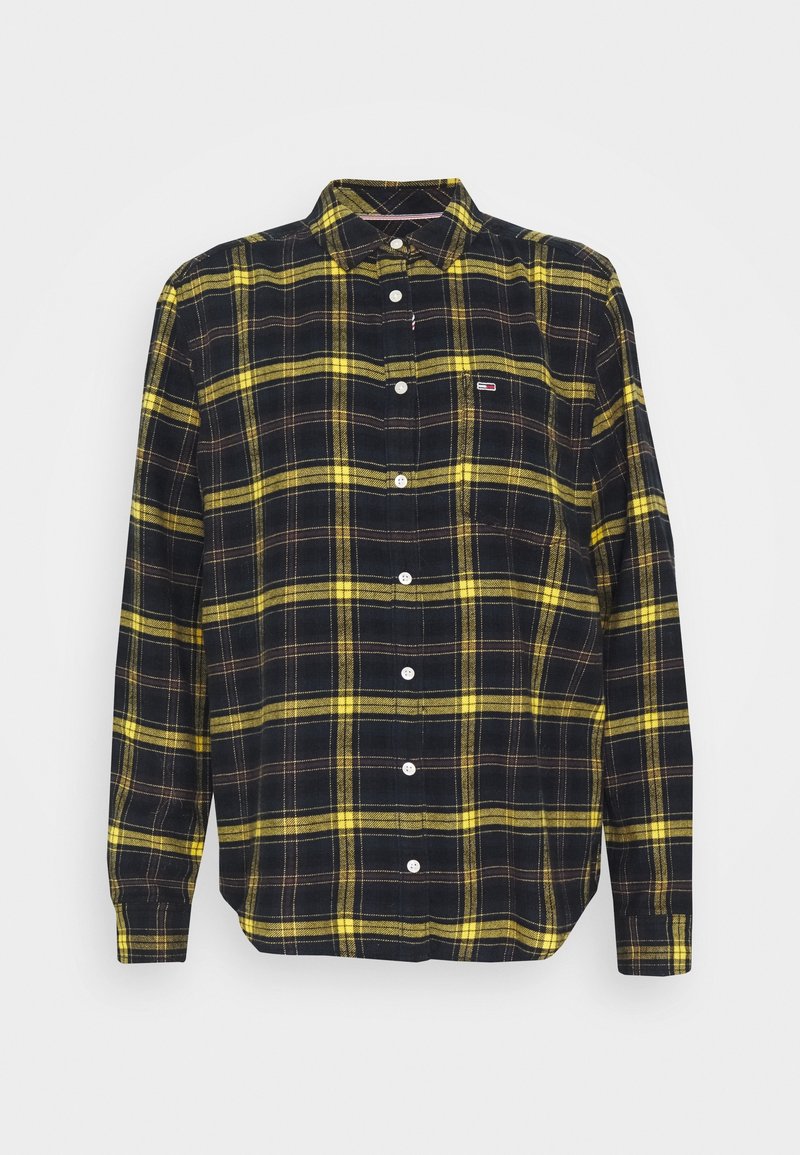 Chemise noire à manches longues boutonnée avec motif à carreaux jaunes et petit logo sur la poche poitrine gauche, présentée sur fond blanc.