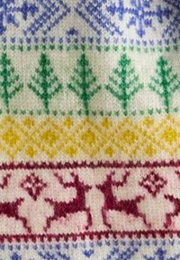 Strickstoff mit einem sich wiederholenden Muster aus Bäumen und Rentieren. Die Farben umfassen Grün, Gelb, Rot und Blau auf einem weißen Hintergrund.